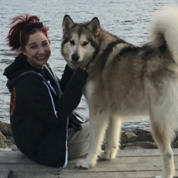 woman with husky dog on dock