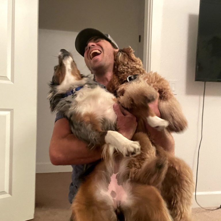 man holding two dogs
